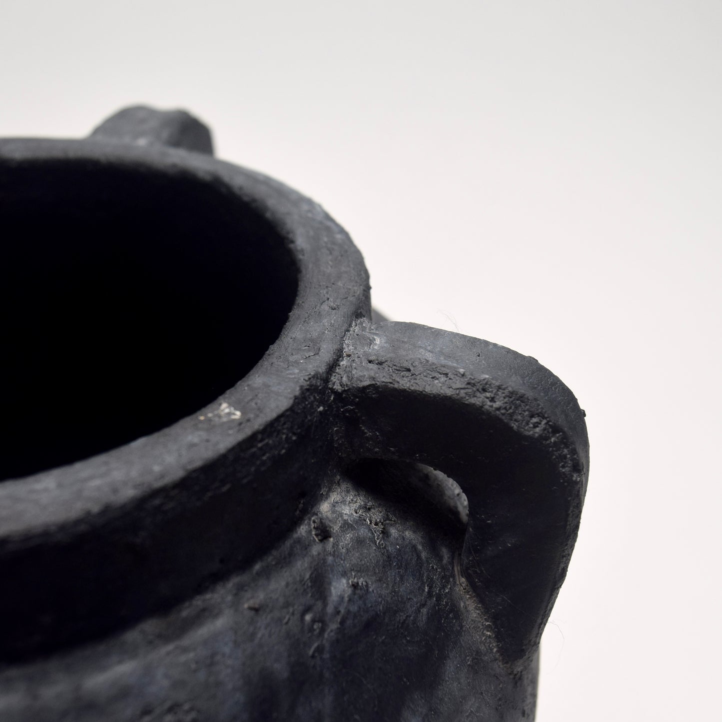 Close-up of a black ceramic pot on a white background