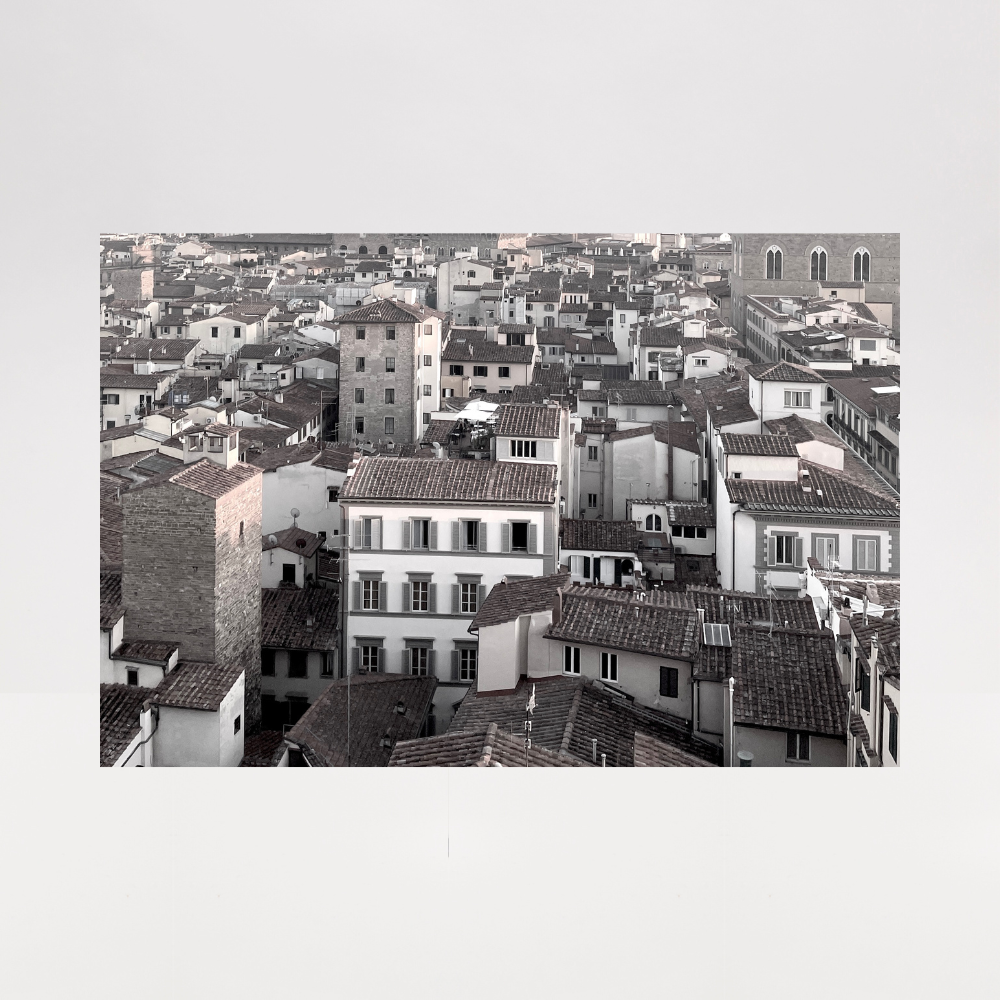 Black and white aerial view of a cityscape with buildings and rooftops.