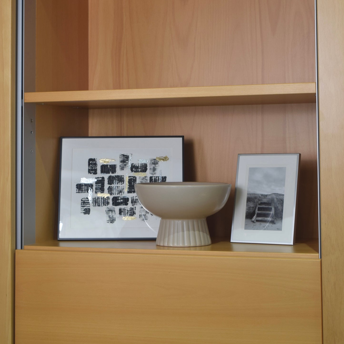 Wooden shelf with a bowl and two framed pictures
