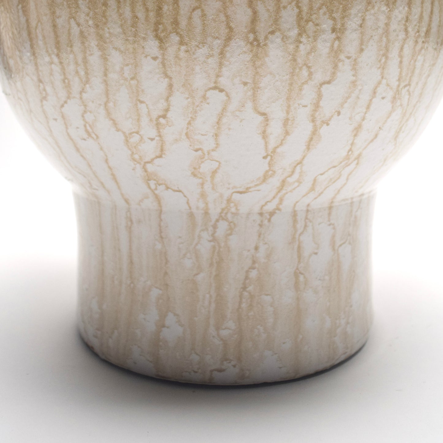 Close-up of a ceramic vase with marbled pattern on a white background