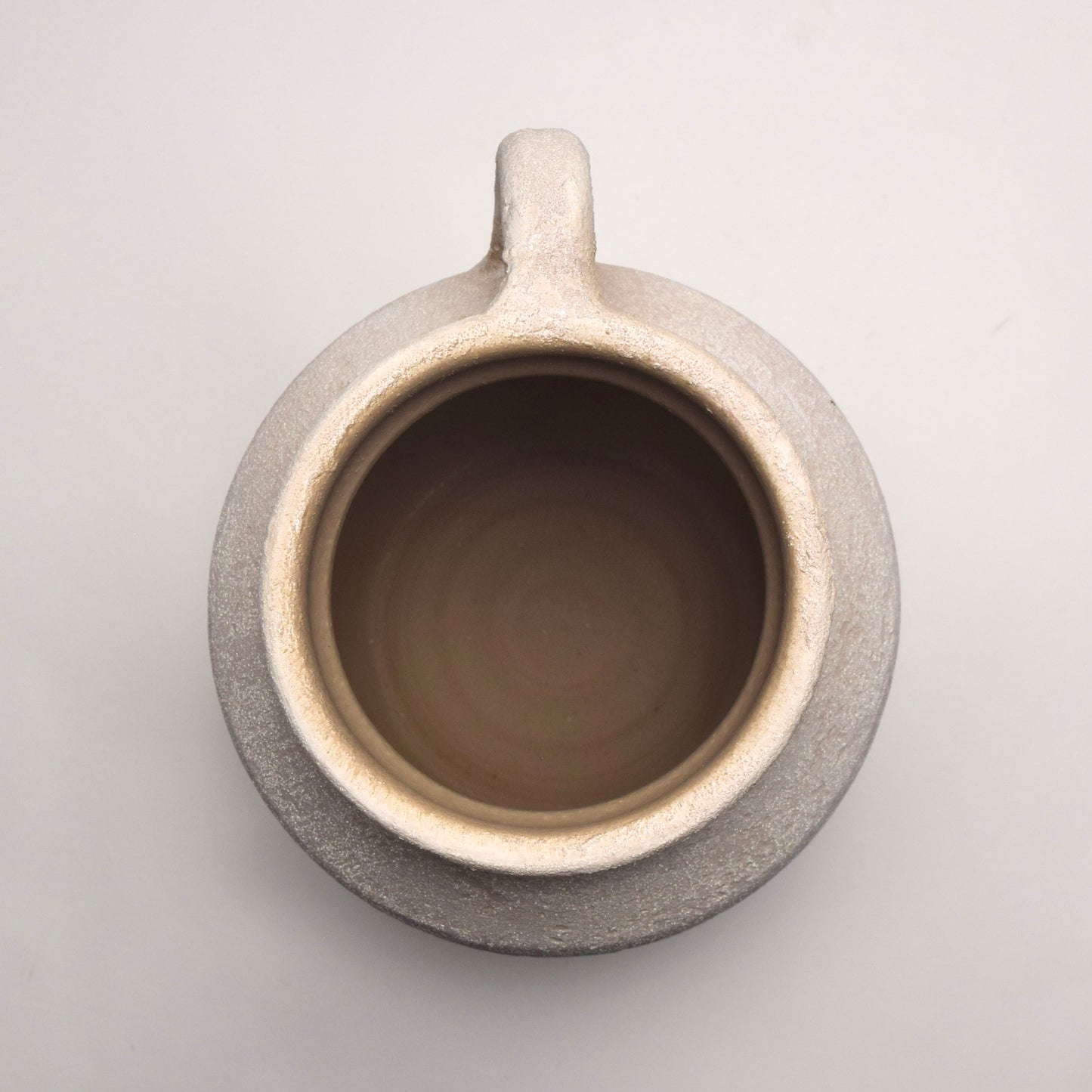 Off-white ceramic vase with a handle, view from the top