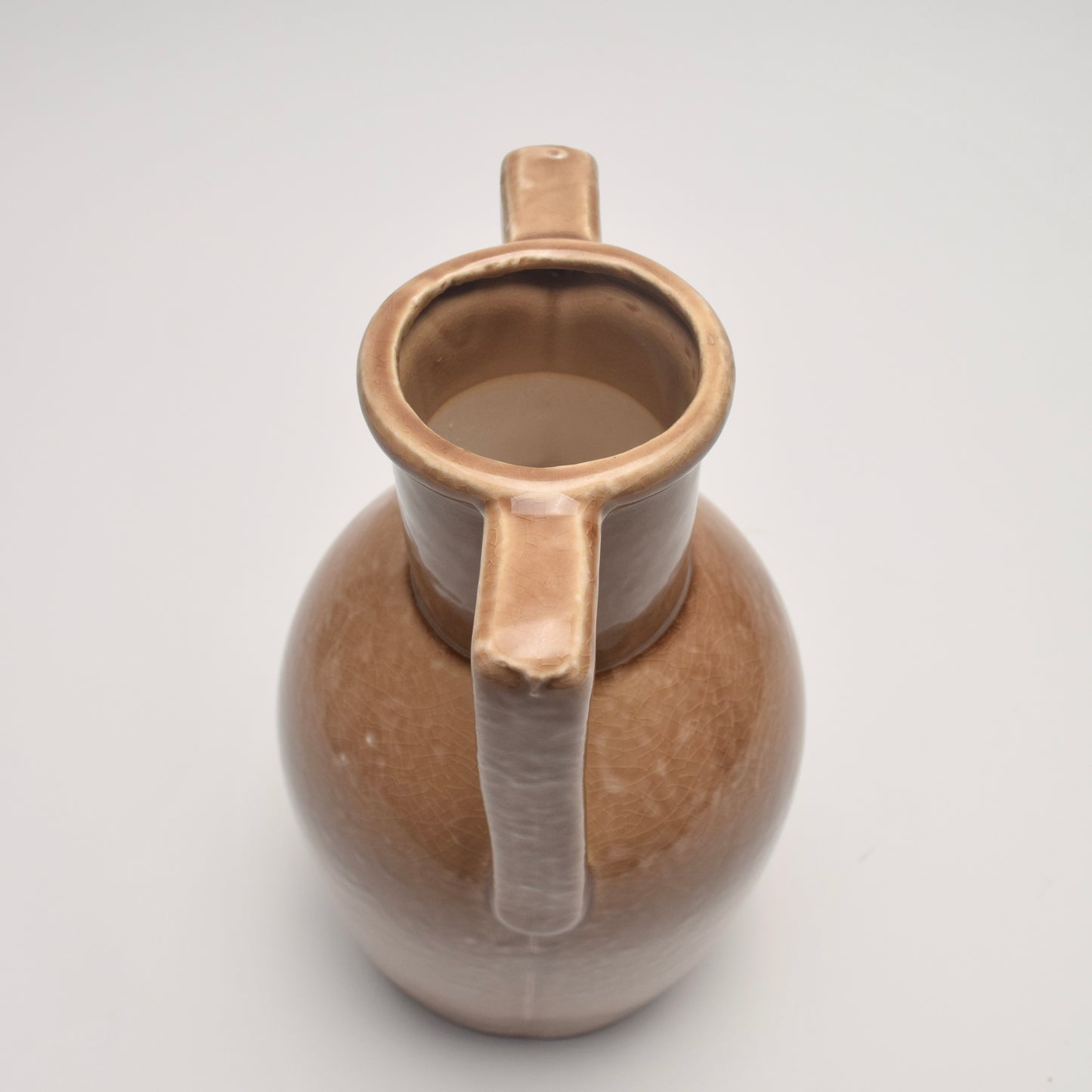 Tan ceramic vase with two handles and rounded body