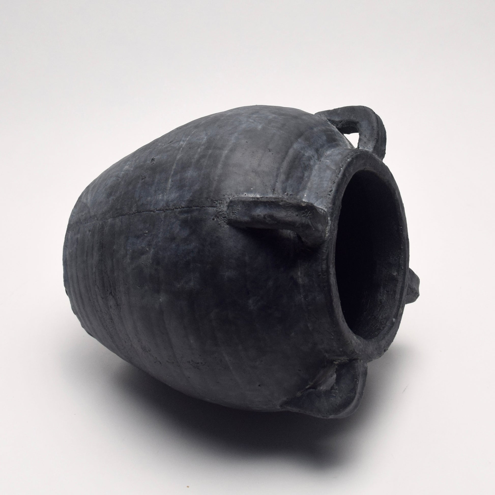 Black ceramic terracotta vase with four handles on its side