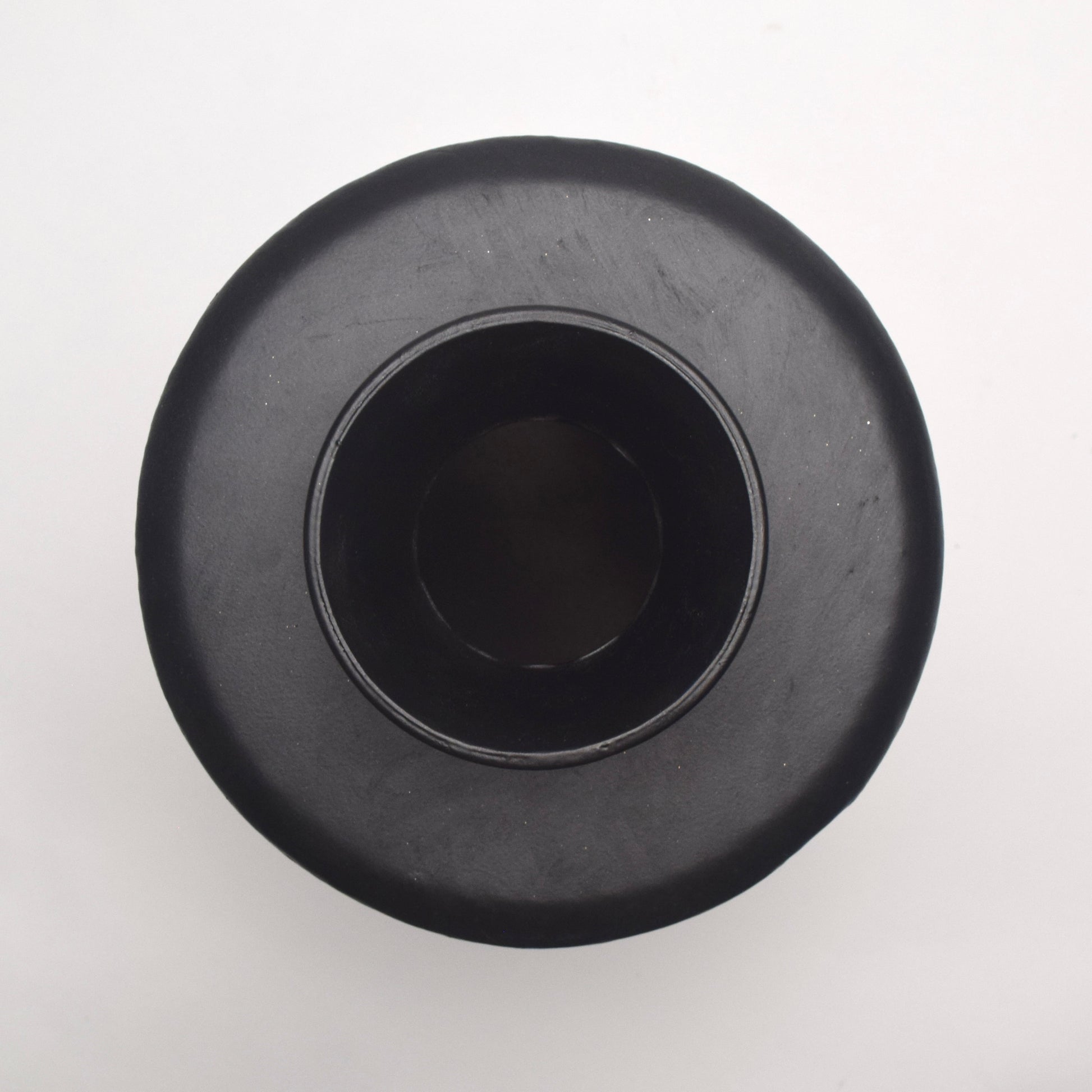 Top view of black metal vase with circular top and cylindrical body