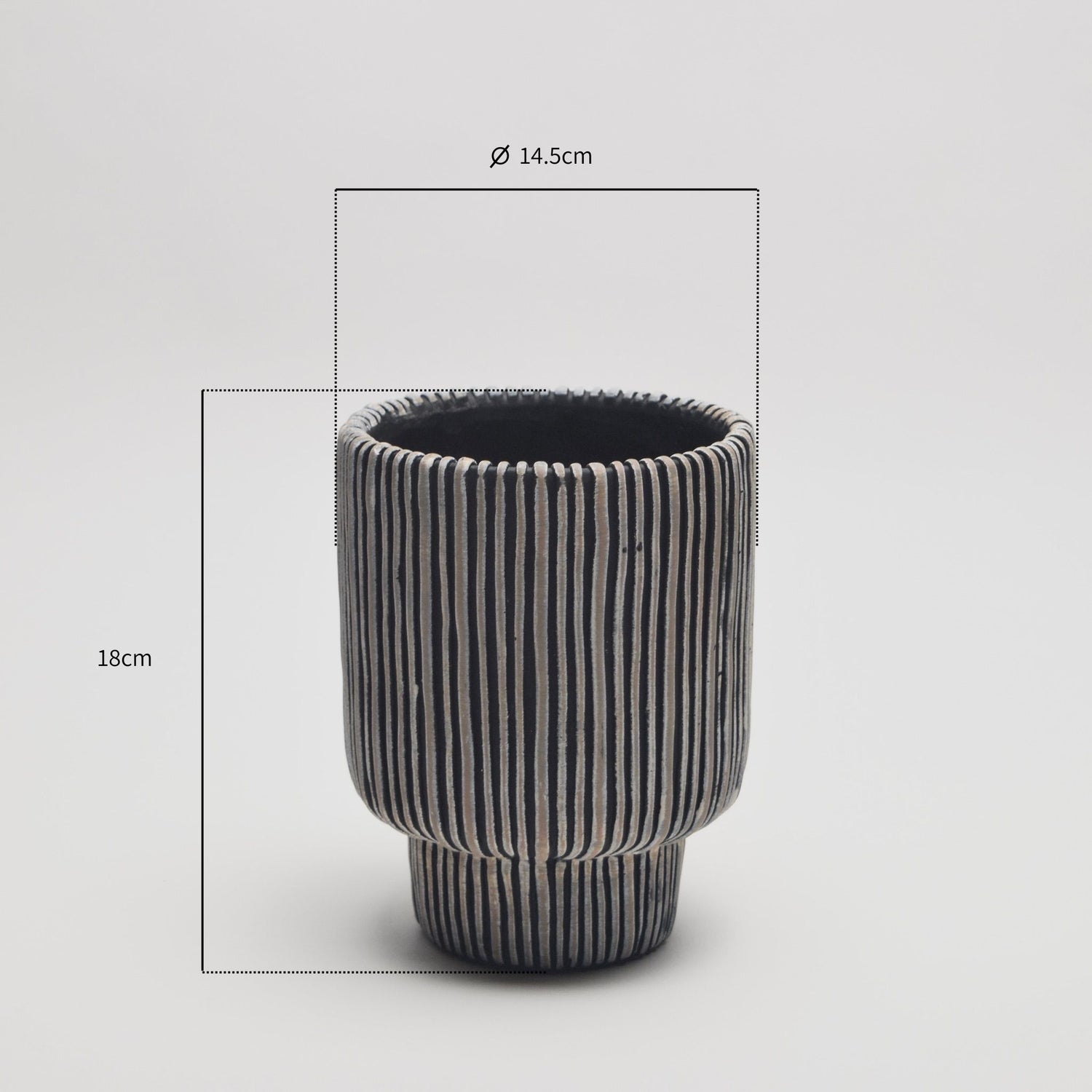 Black ribbed vase with measurements on a light grey background