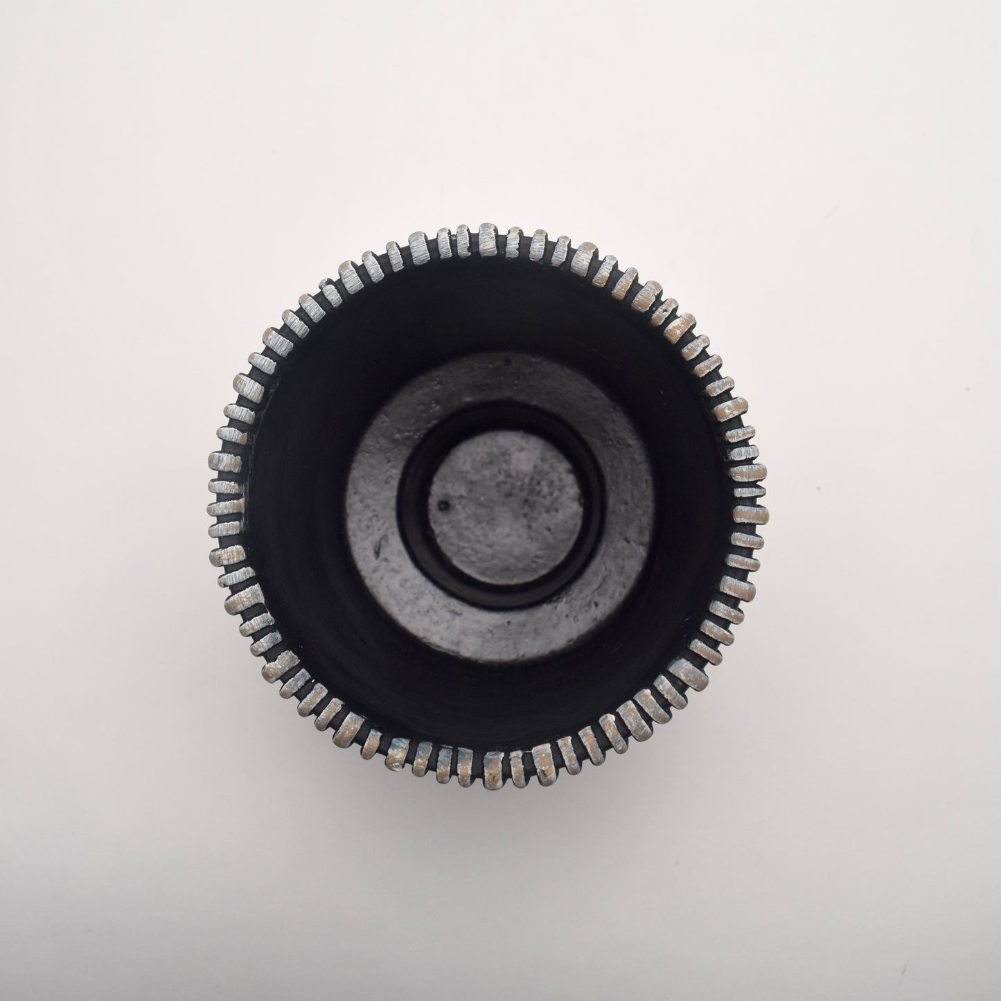 Top view looking down at cylindrical ceramic planter with ribbed texture and black and neutral vertical stripes 