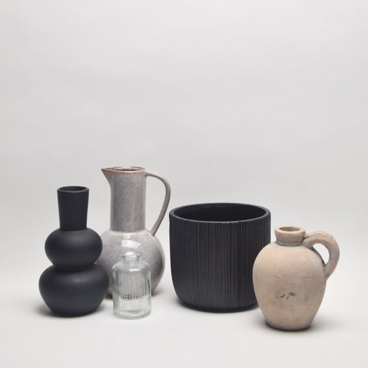 Collection of ceramic and glass vessels including vases and plant pots for neutral shelf styling