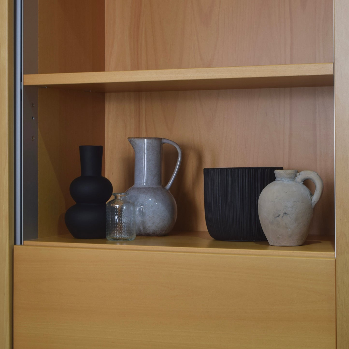 Set of ceramic vases on a wooden shelf
