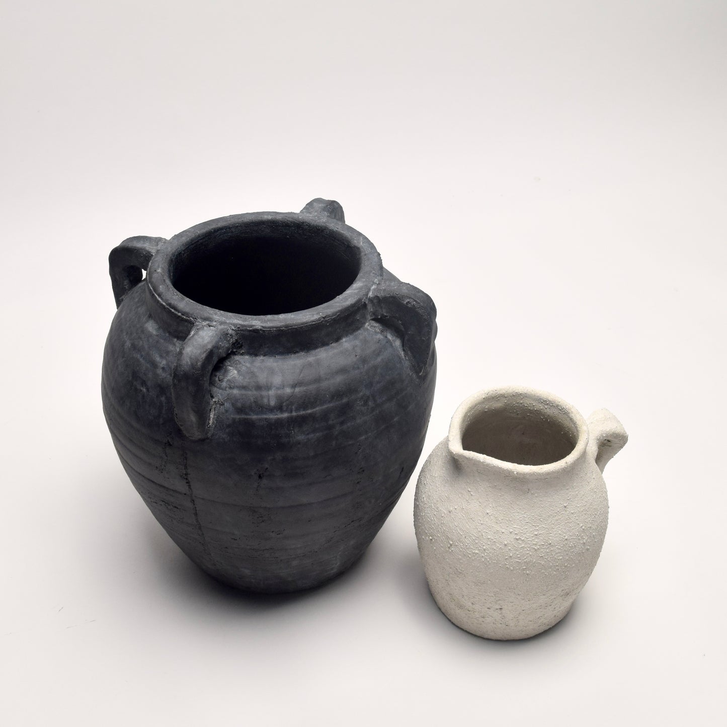Curated set featuring a black terracotta amphora vase and a textured off-white ceramic jug