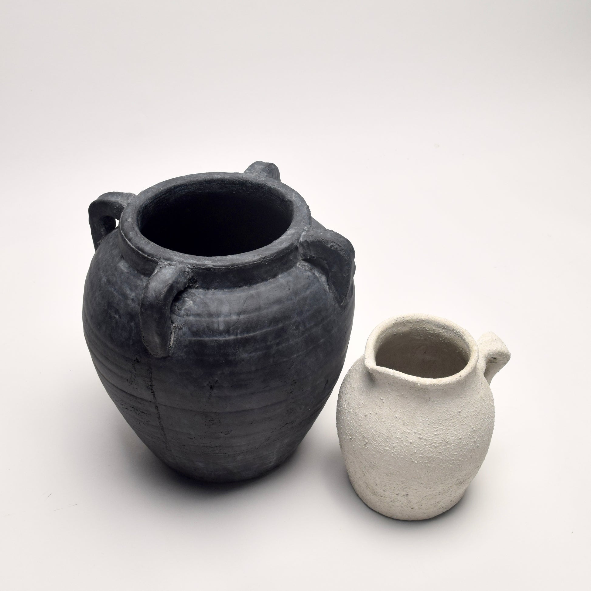 Curated set featuring a black terracotta amphora vase and a textured off-white ceramic jug