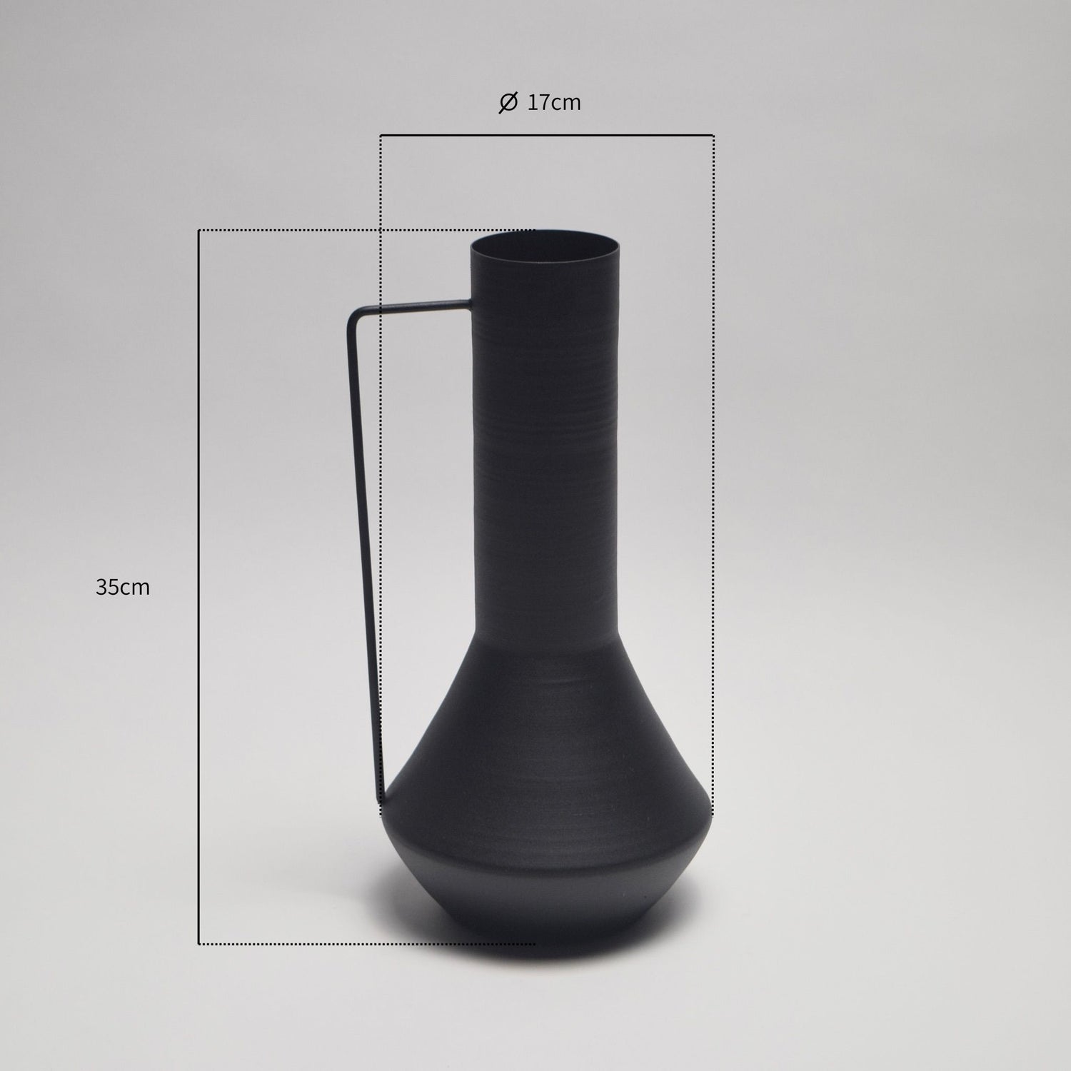 Black vase with a thin handle on a plain background with annotated dimensions shown. 