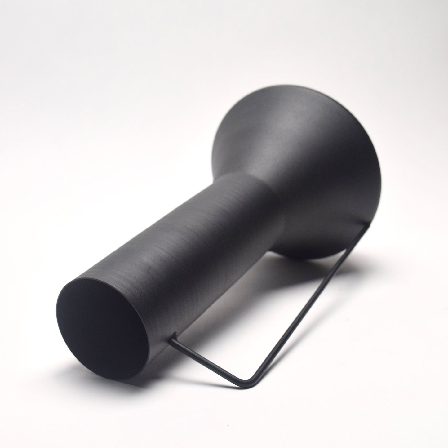 Tall matt black vase with a thin handle and funnel top section