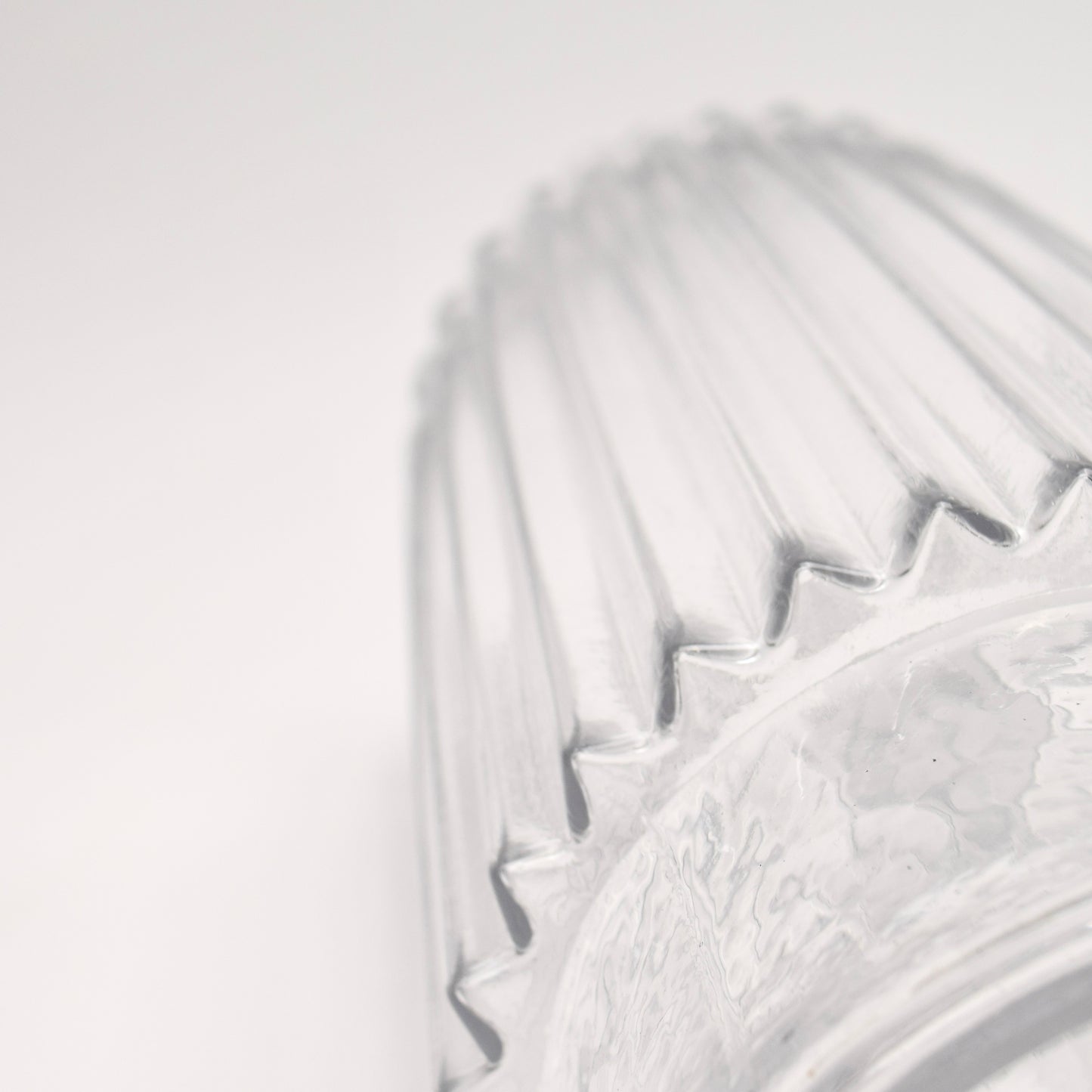 Close-up detail of clear glass vase with ribbed design 
