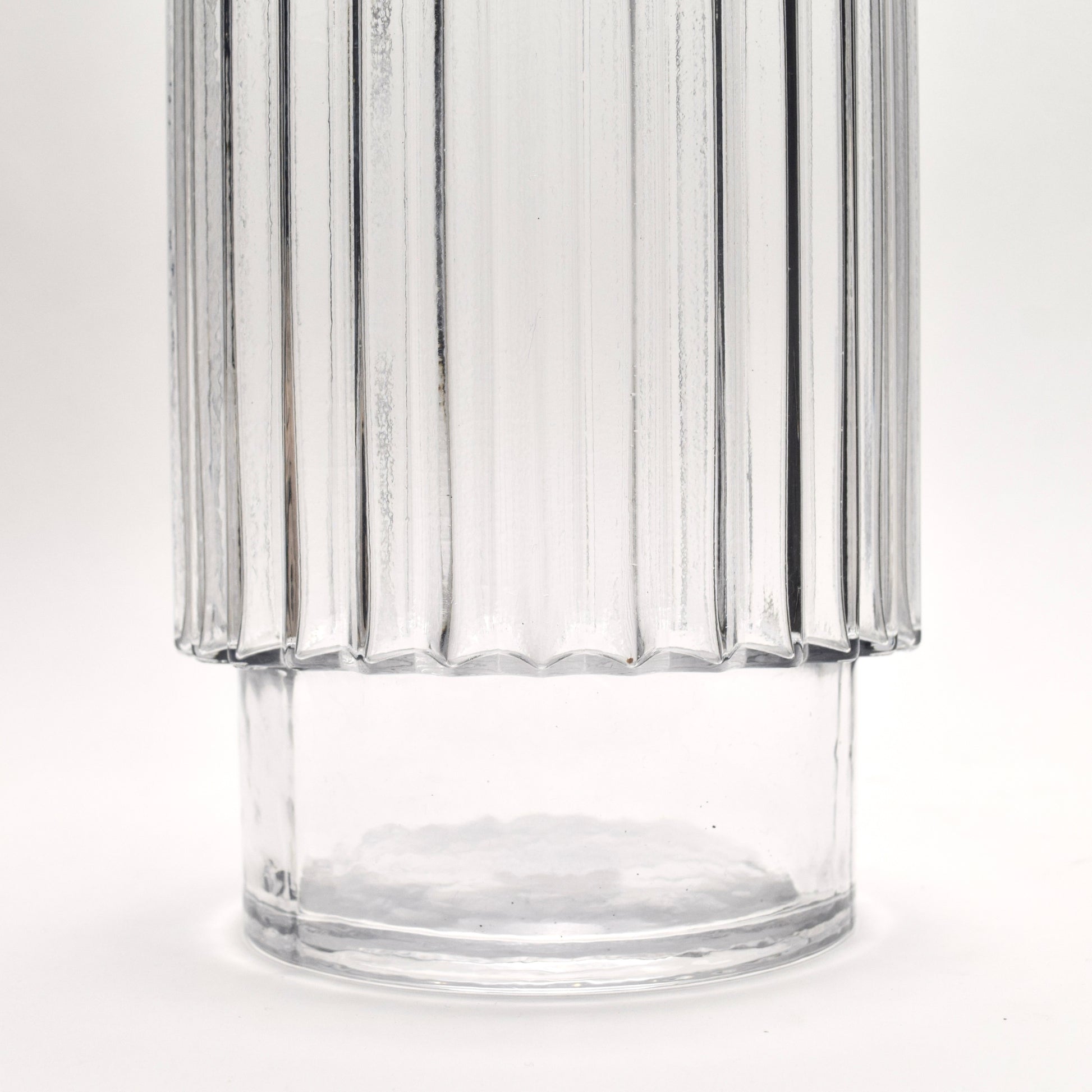Close-up of clear glass vase with ribbed design and pedestal shape