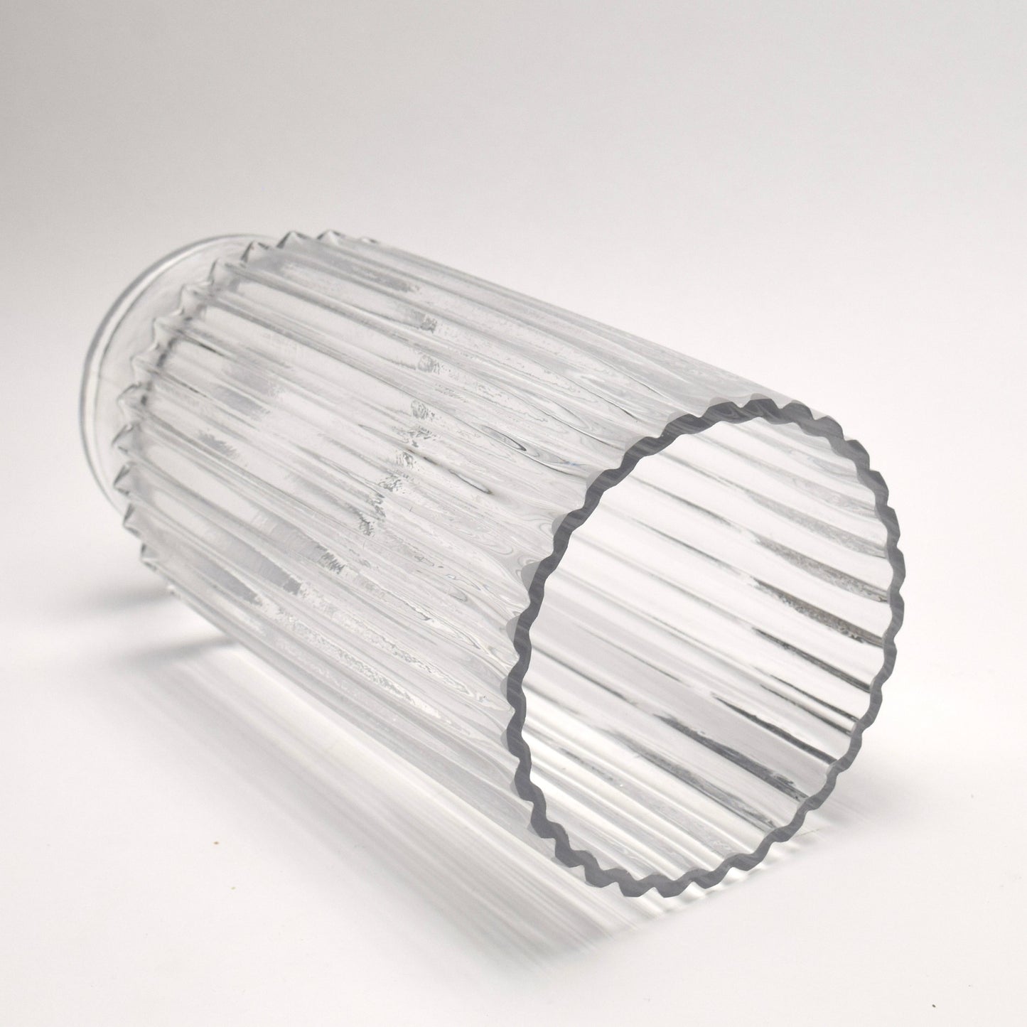 Clear glass vase with ribbed design on a white background
