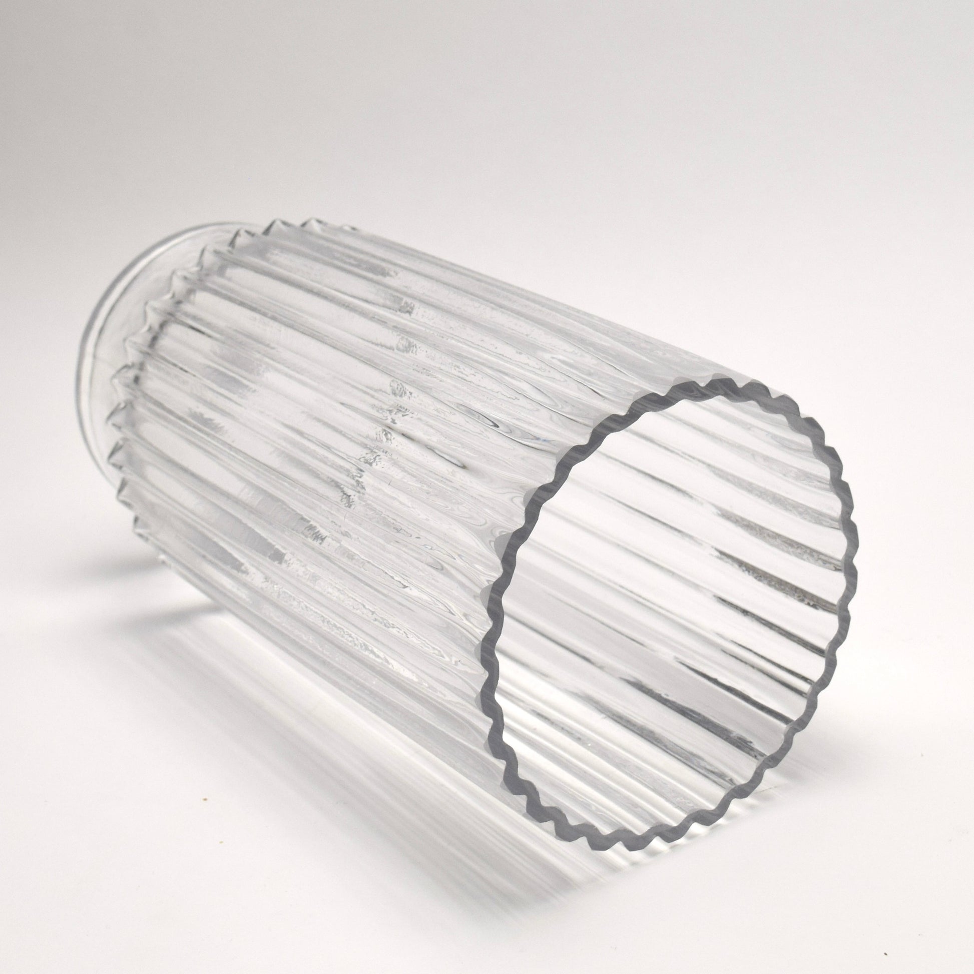 Clear glass vase with ribbed design on a white background