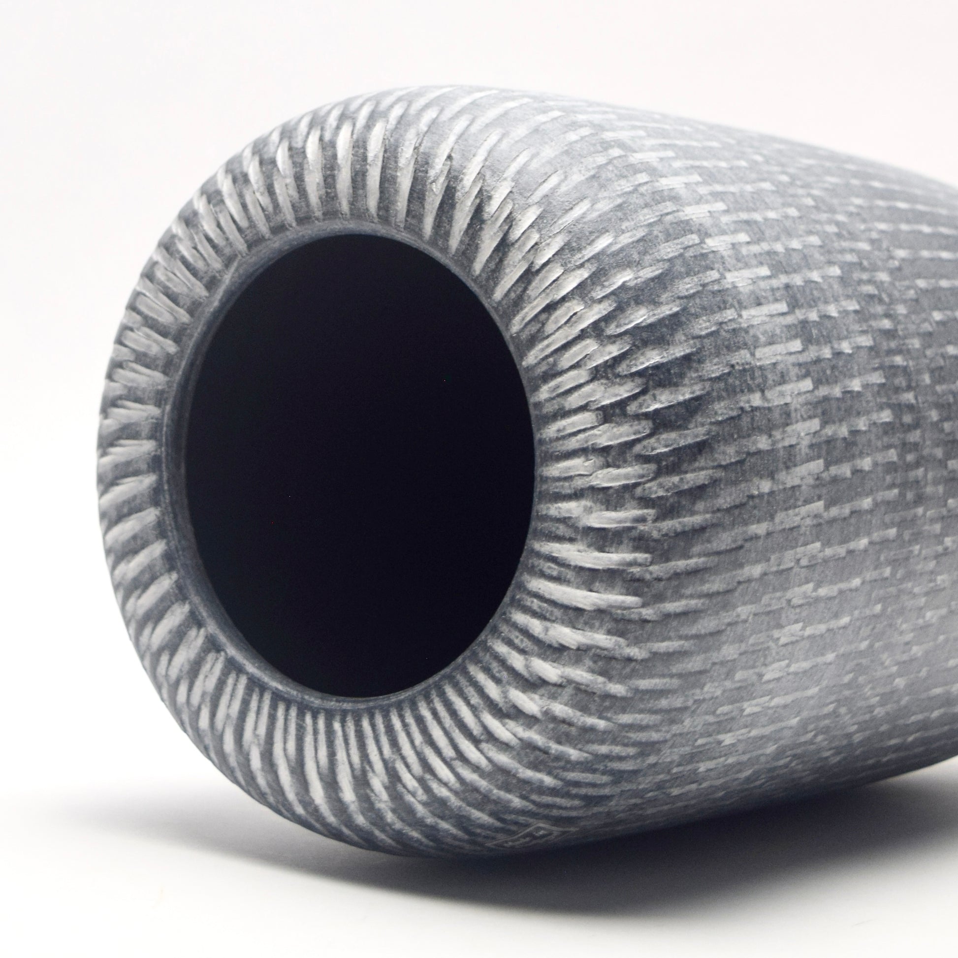 Grey cylindrical vase with striking white linear pattern