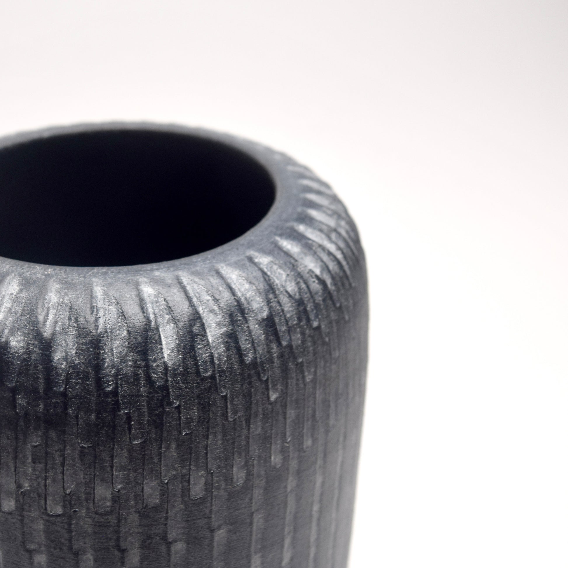 Top of grey terracotta vase with textured a linear pattern detail