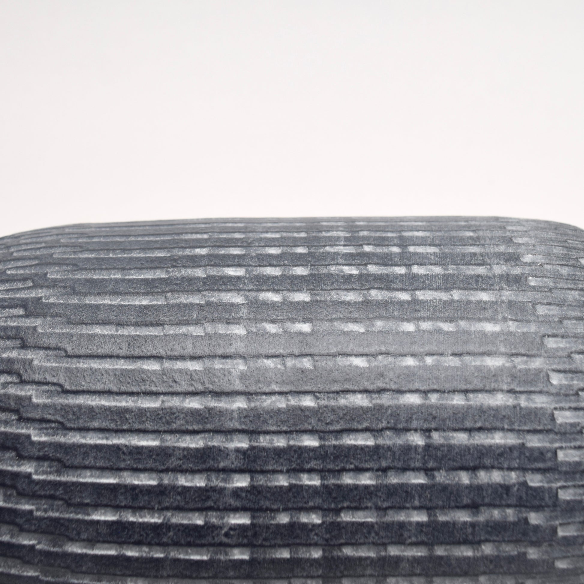 Close-up of pattern on grey terracotta cylindrical vase