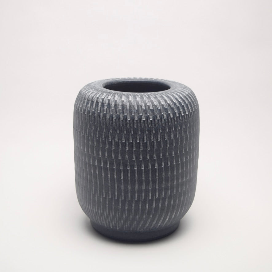 Textured grey vase with a pillar shape and linear pattern for contemporary home shelf styling