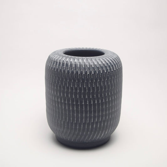 Textured grey vase with a pillar shape and linear pattern for contemporary home shelf styling
