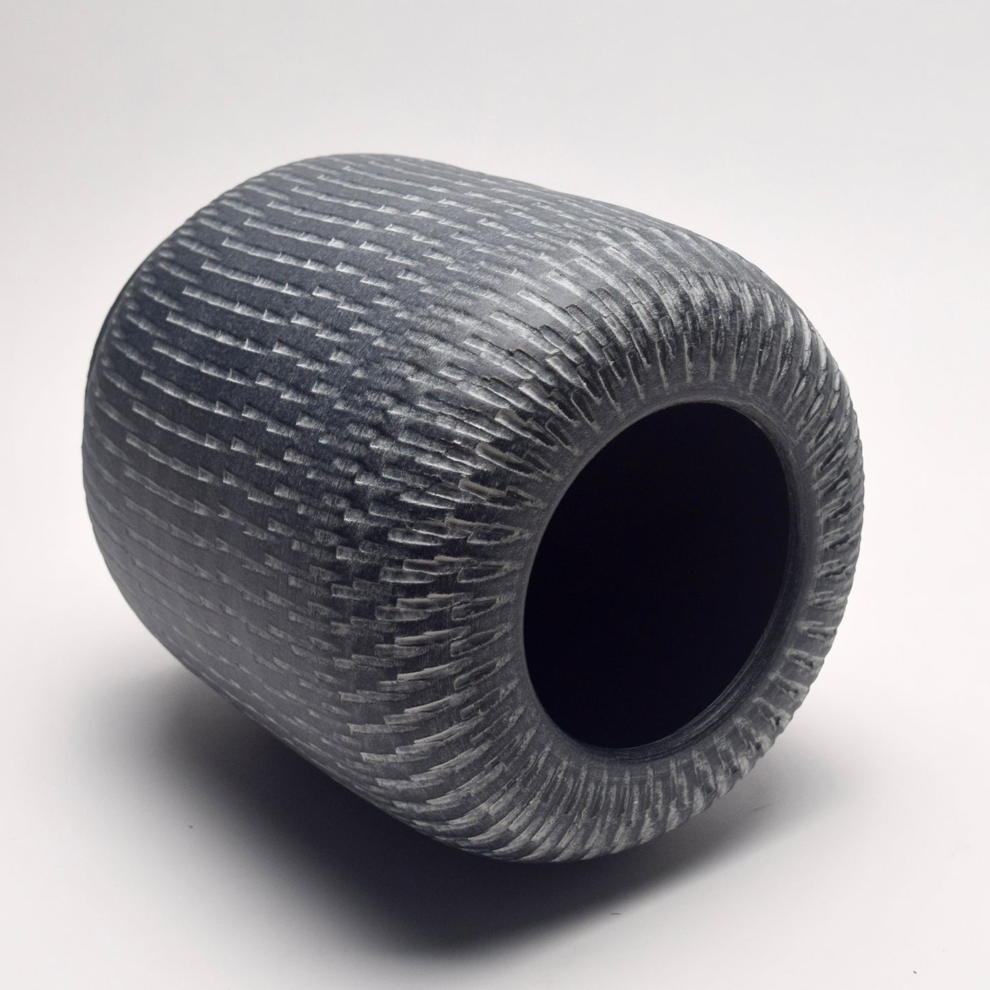 Textured grey vase with a pillar shape and linear pattern on its side