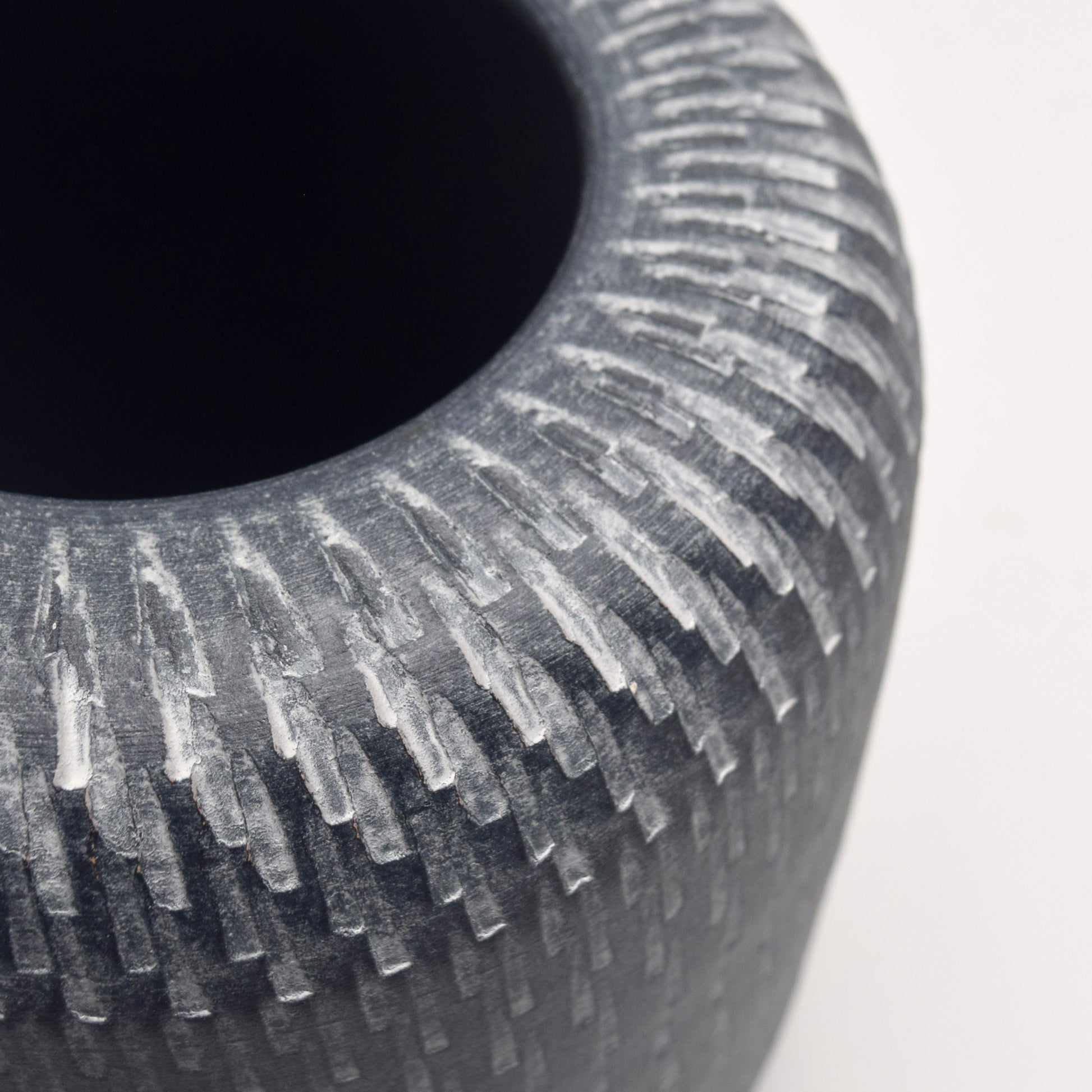 Close-up of a textured grey and white ceramic vase 