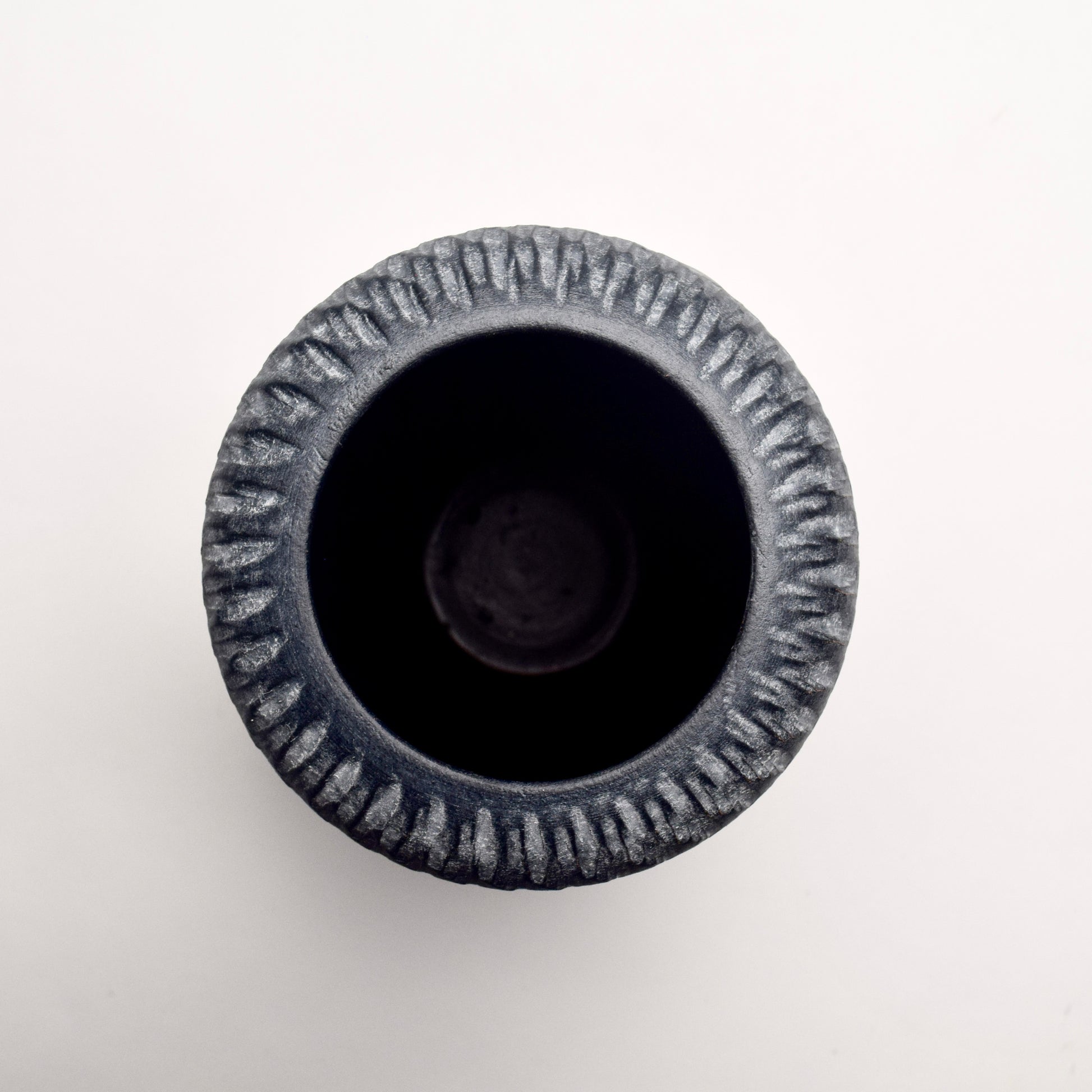 Top rim of grey textured terracotta vase with white linear pattern