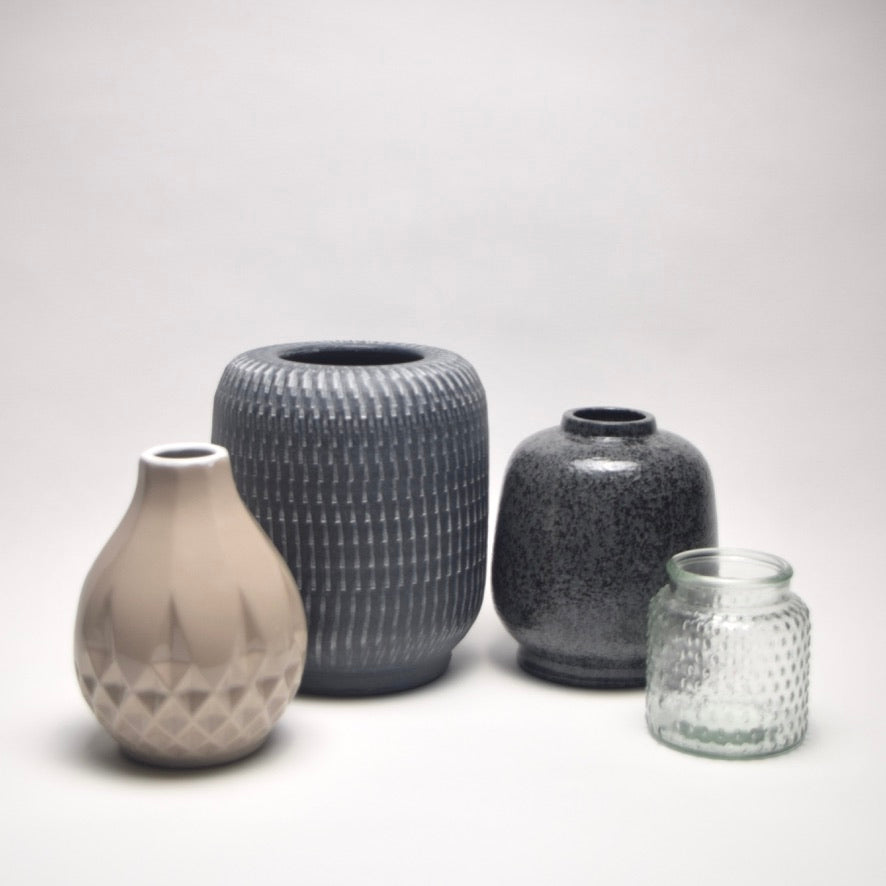Four ceramic vases of different shapes and sizes which are taupe and grey for neutral home styling