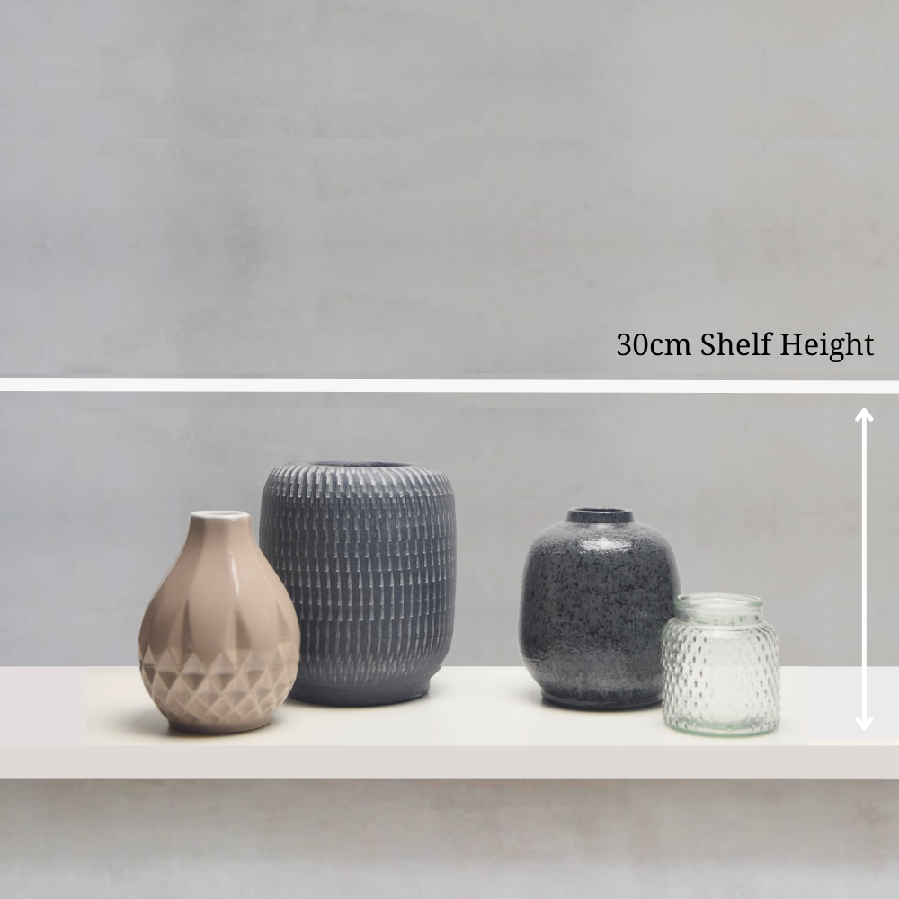 Four vases of different sizes on a shelf with a grey background and measurement text.