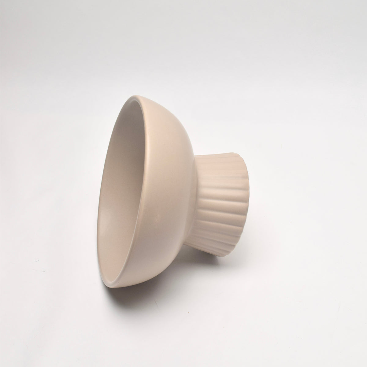 A ceramic bowl-shaped light fixture with a fluted base, shown at an angle on a clean white background.