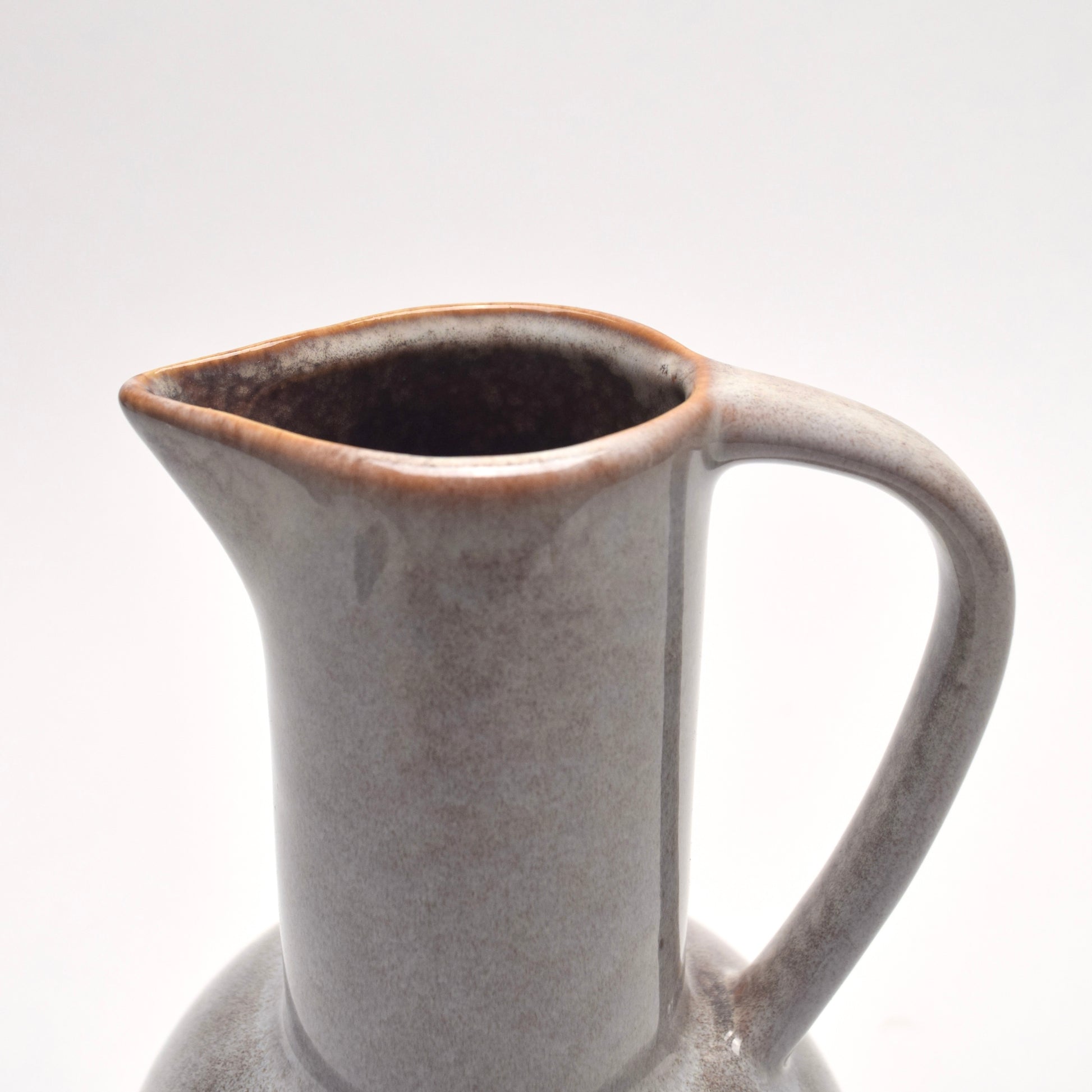 Decorative jug for display showing details of the neck of the grey with brown speckles jug and its handle
