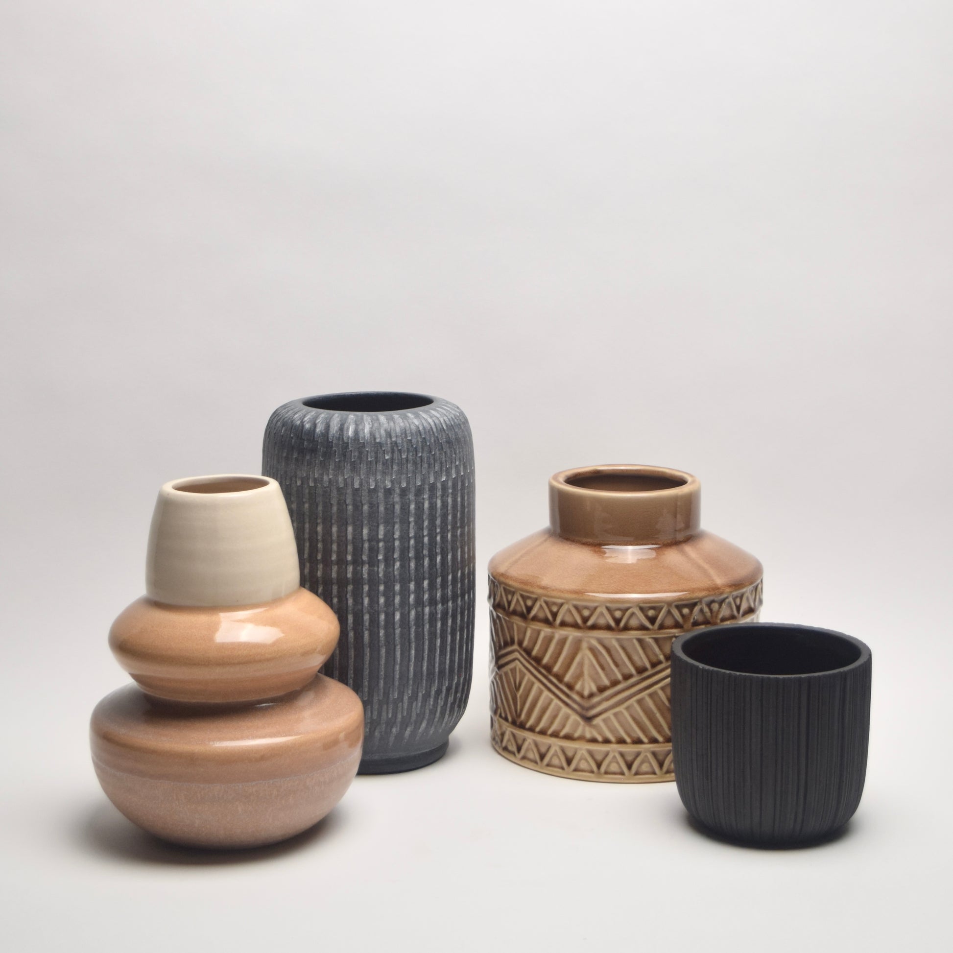 Set of four ceramic vases with different patterns and textures for a warm neutral interior scheme