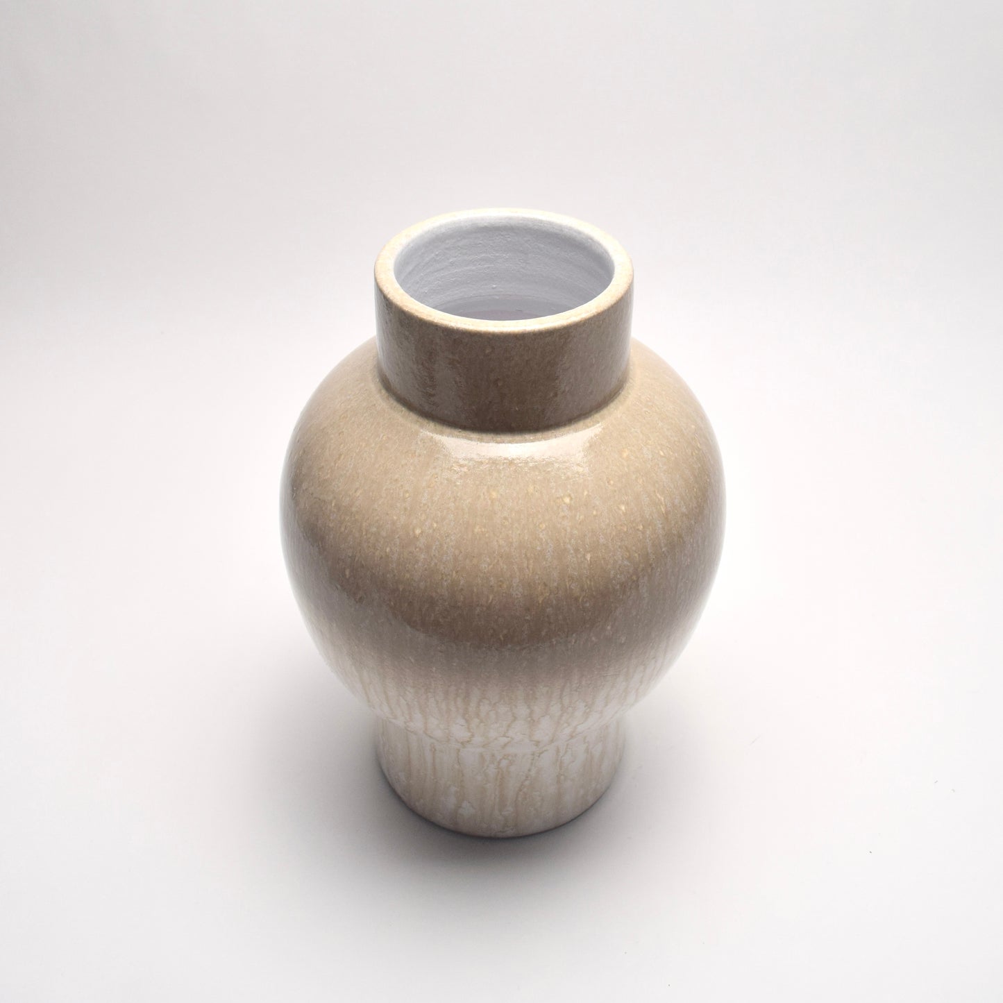 Neutral ceramic vase with a patterned surface on a white background