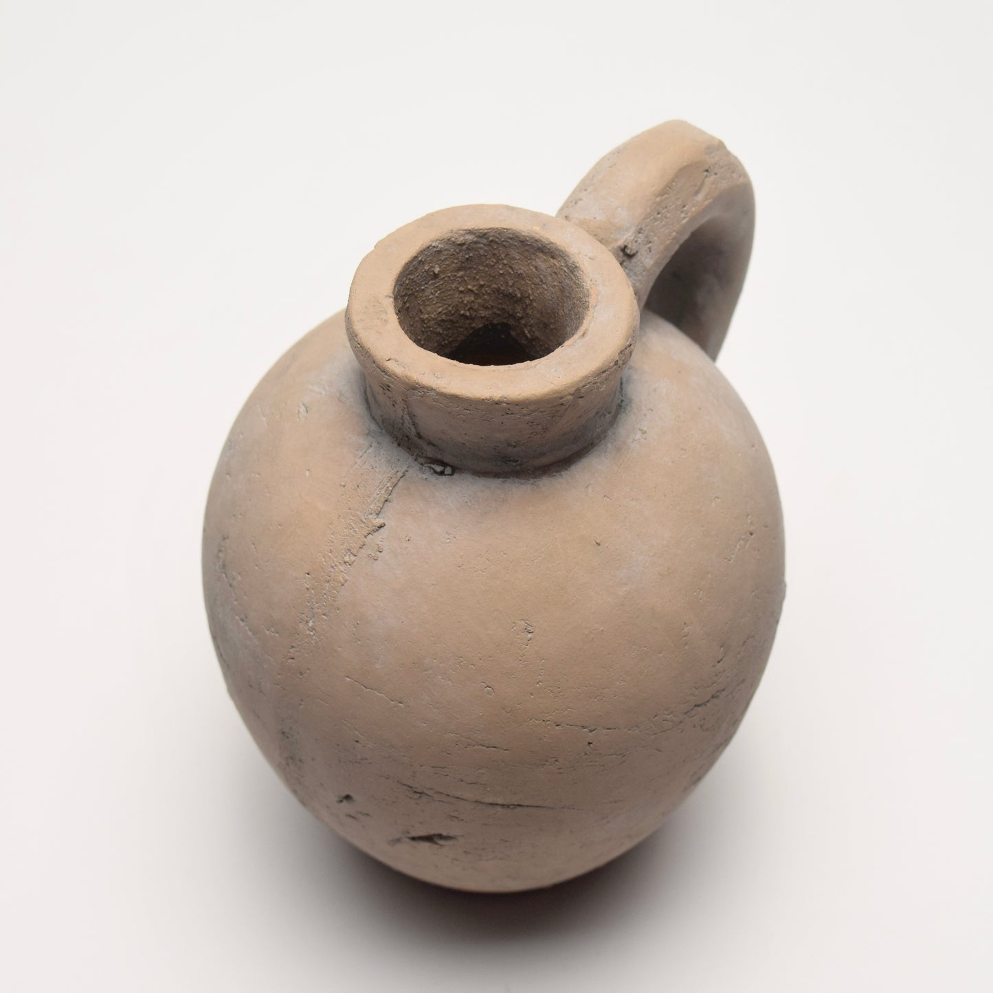 Stone jug with curved shape and small handle
