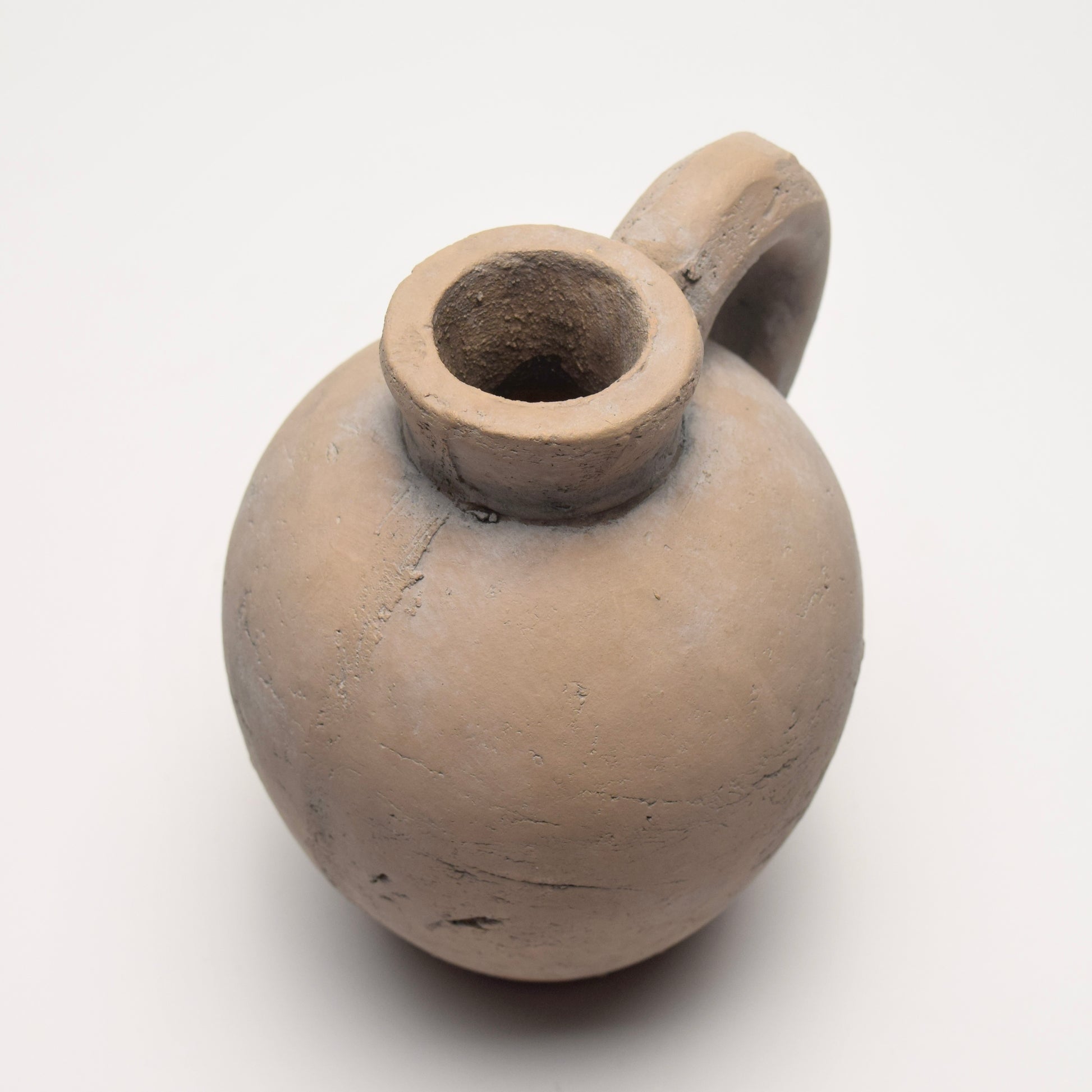 Stone jug with curved shape and small handle