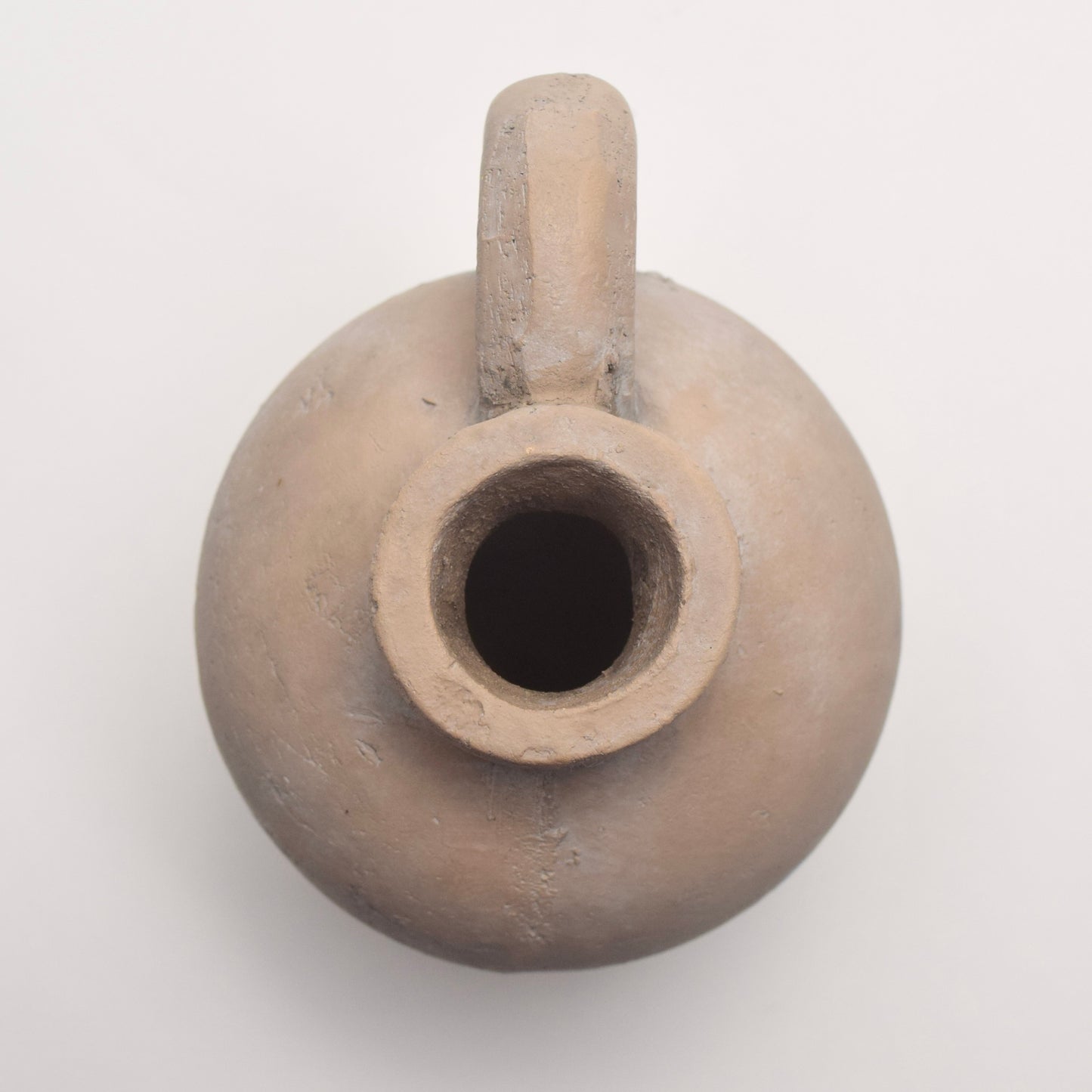 Small neutral clay pot with a handle