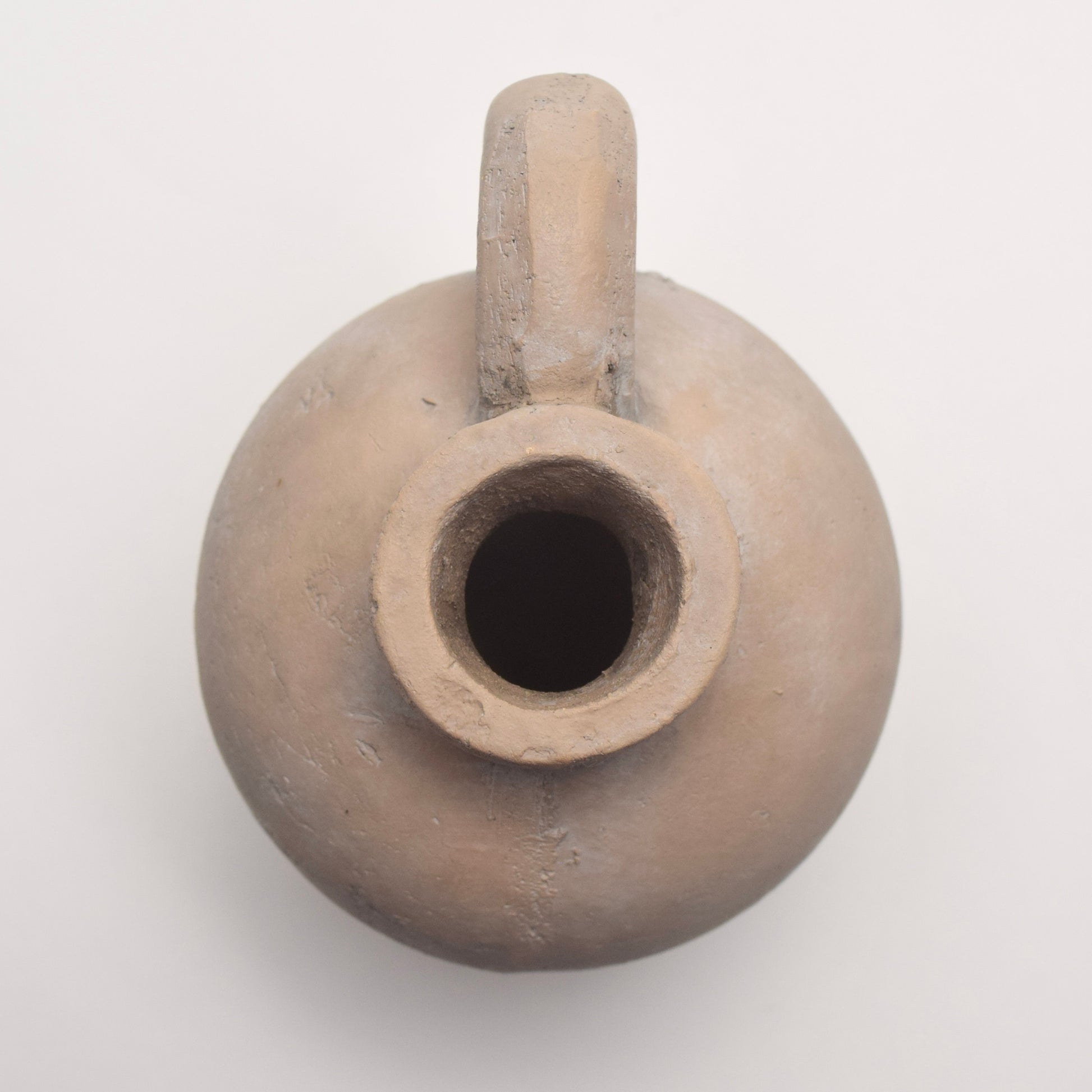 Small neutral clay pot with a handle