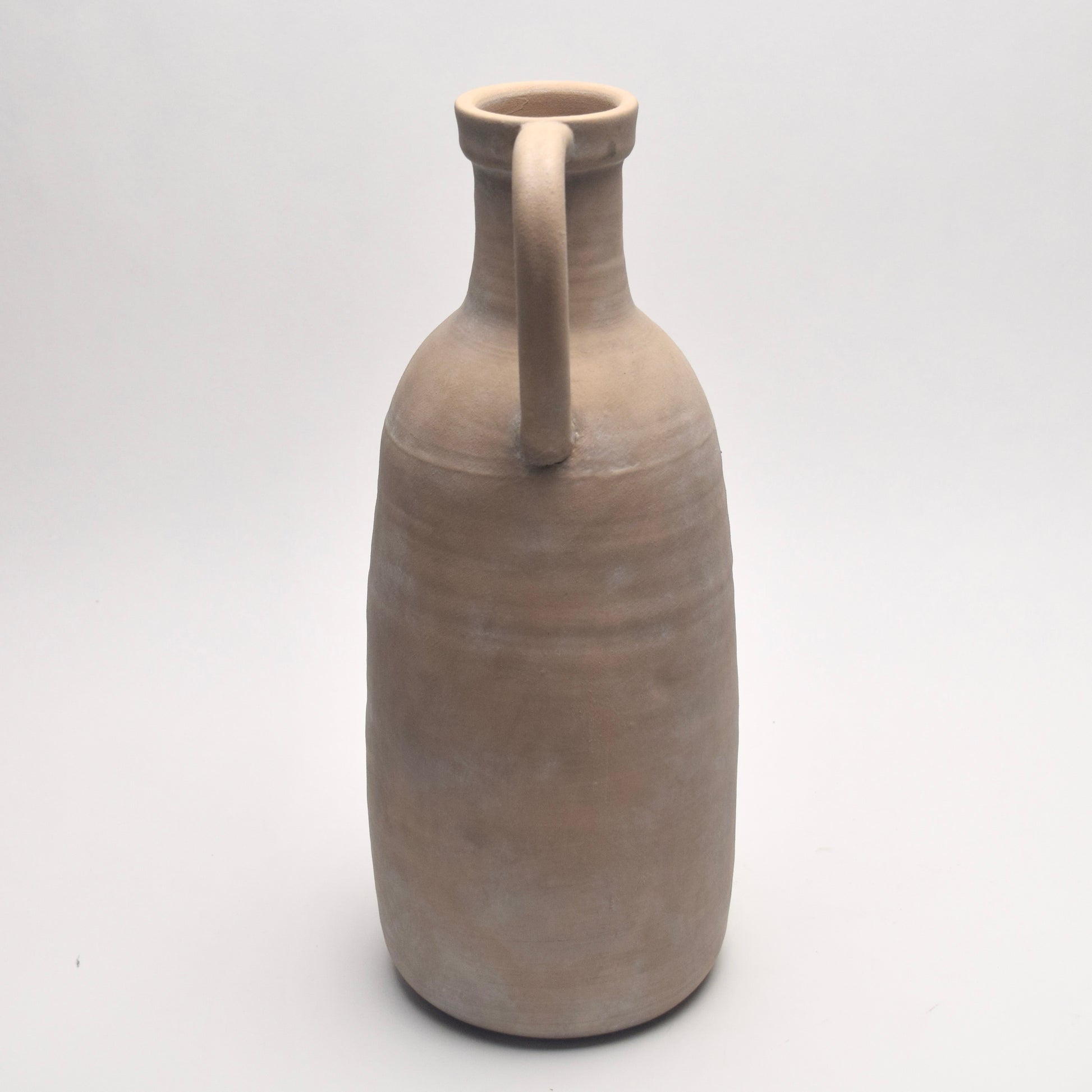 Stone neutral  ceramic vase with a handle on a white background