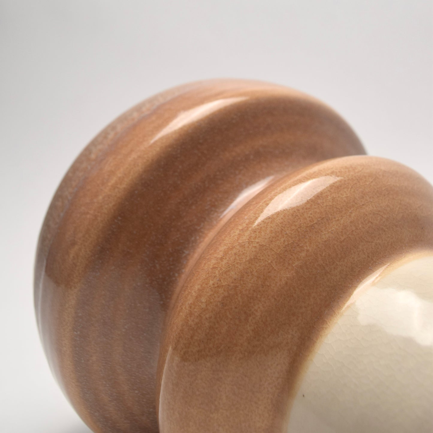 Close-up of a cream, tan and brown ceramic vase 
