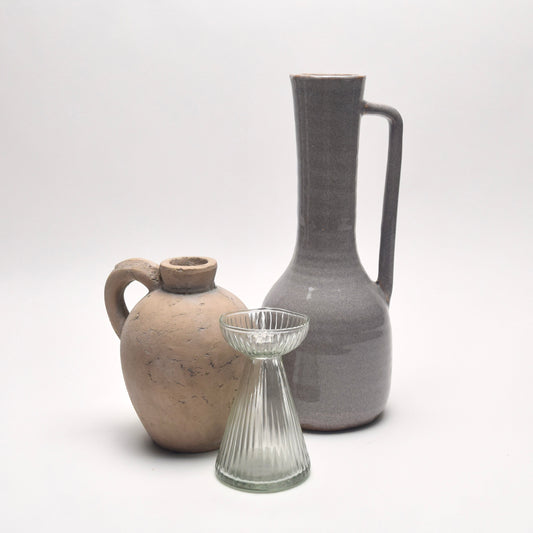tall grey ceramic vase with small curved stoneware jug and ribbed striped glass vase.