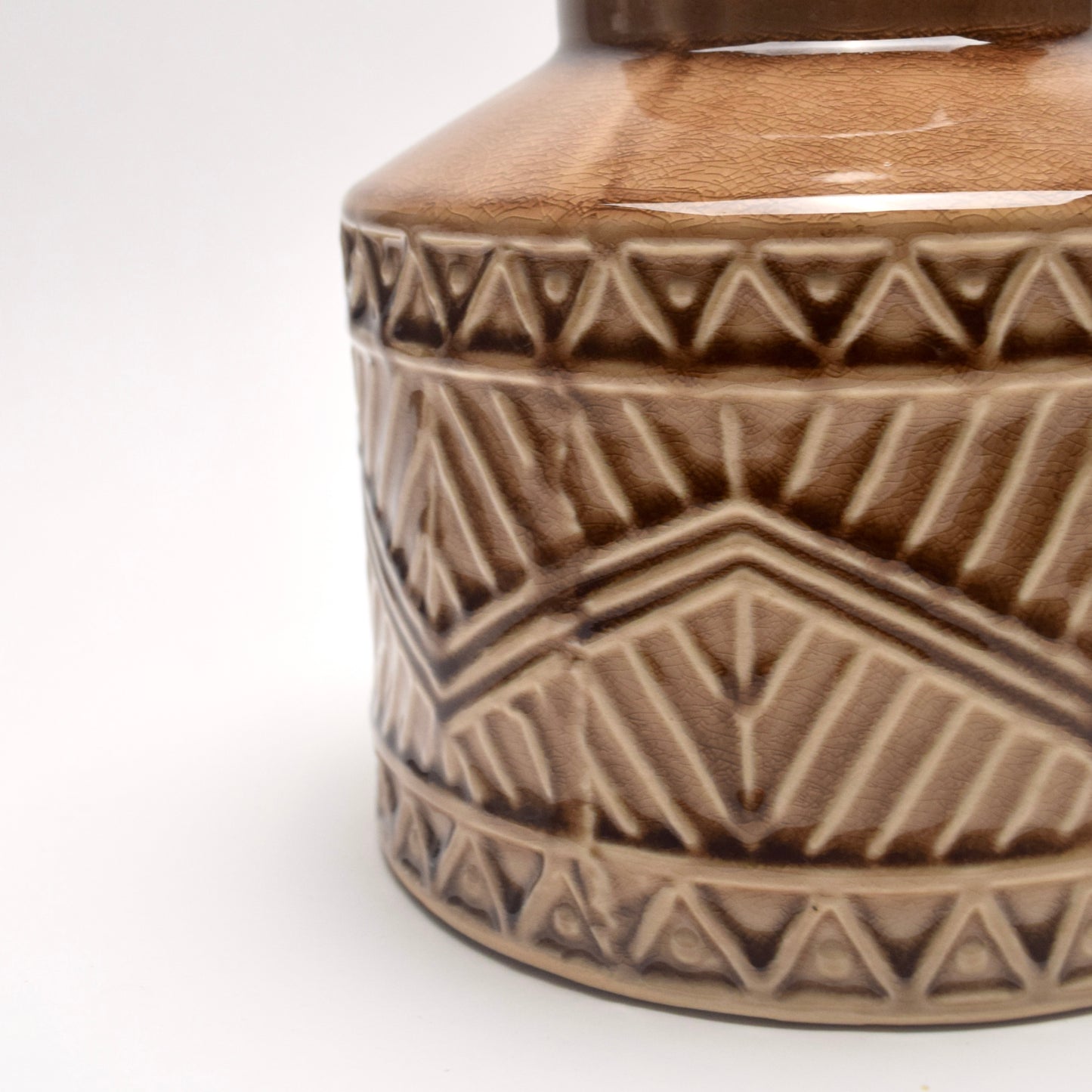 Close-up of Tan, brown, ceramic vase with geometric aztec pattern 
