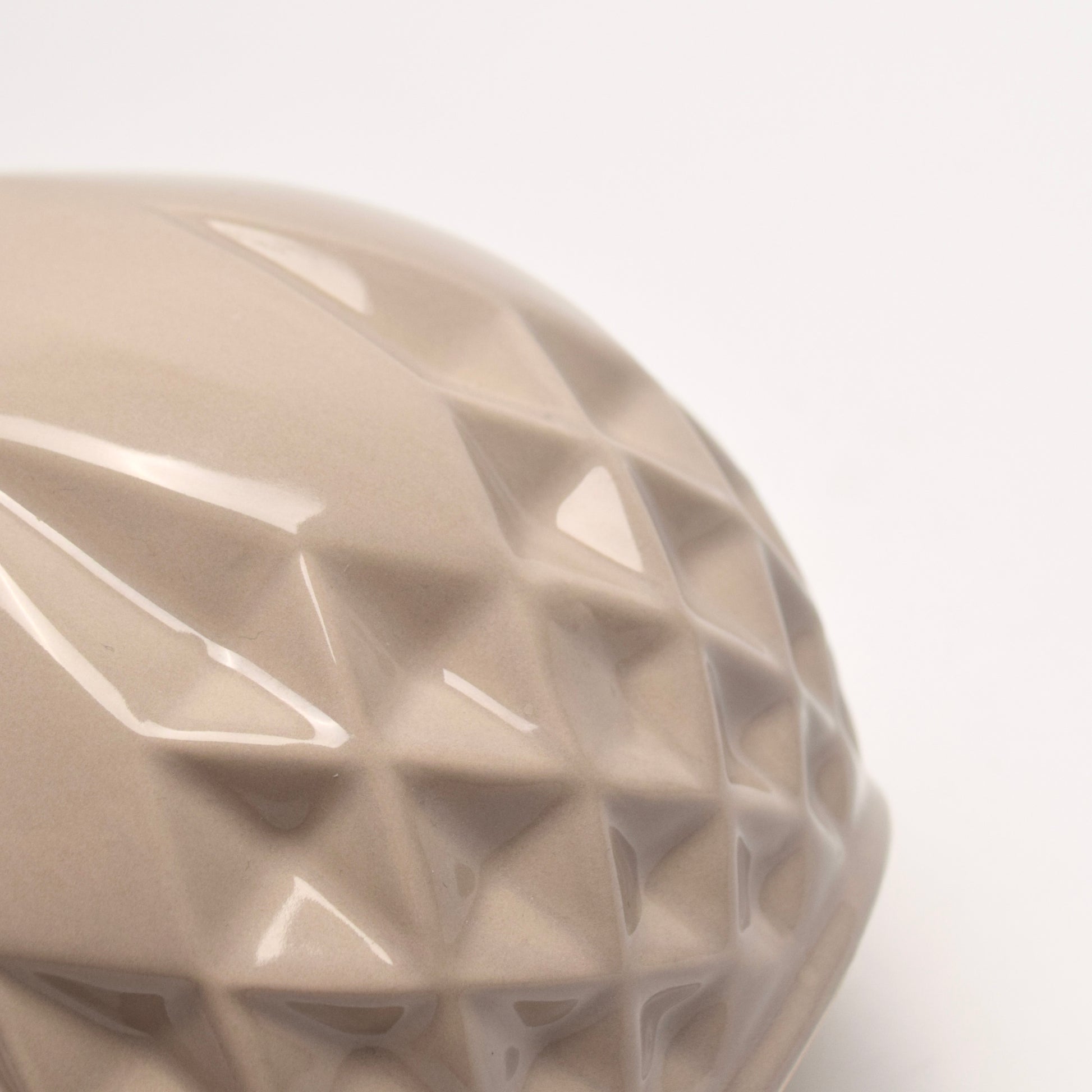 Close-up of a textured geometric diamond pattern taupe ceramic vase
