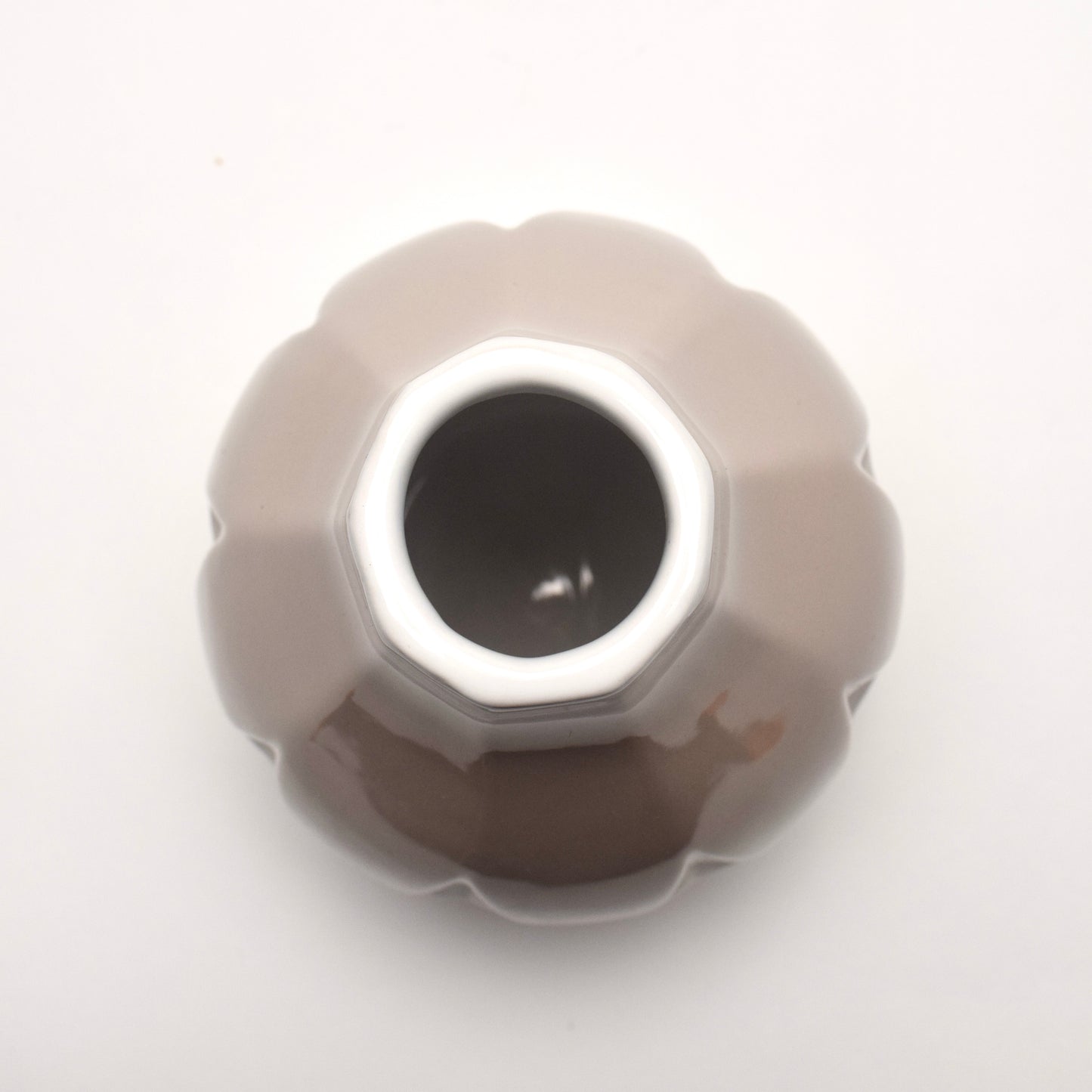 Round ceramic vase with a central hole with white rim and beige taupe coloured body