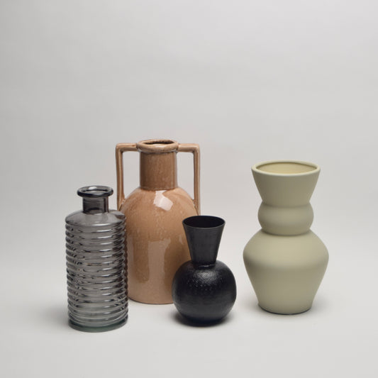 Four ceramic and glass vases of different shapes and colours from black to tan and ecru